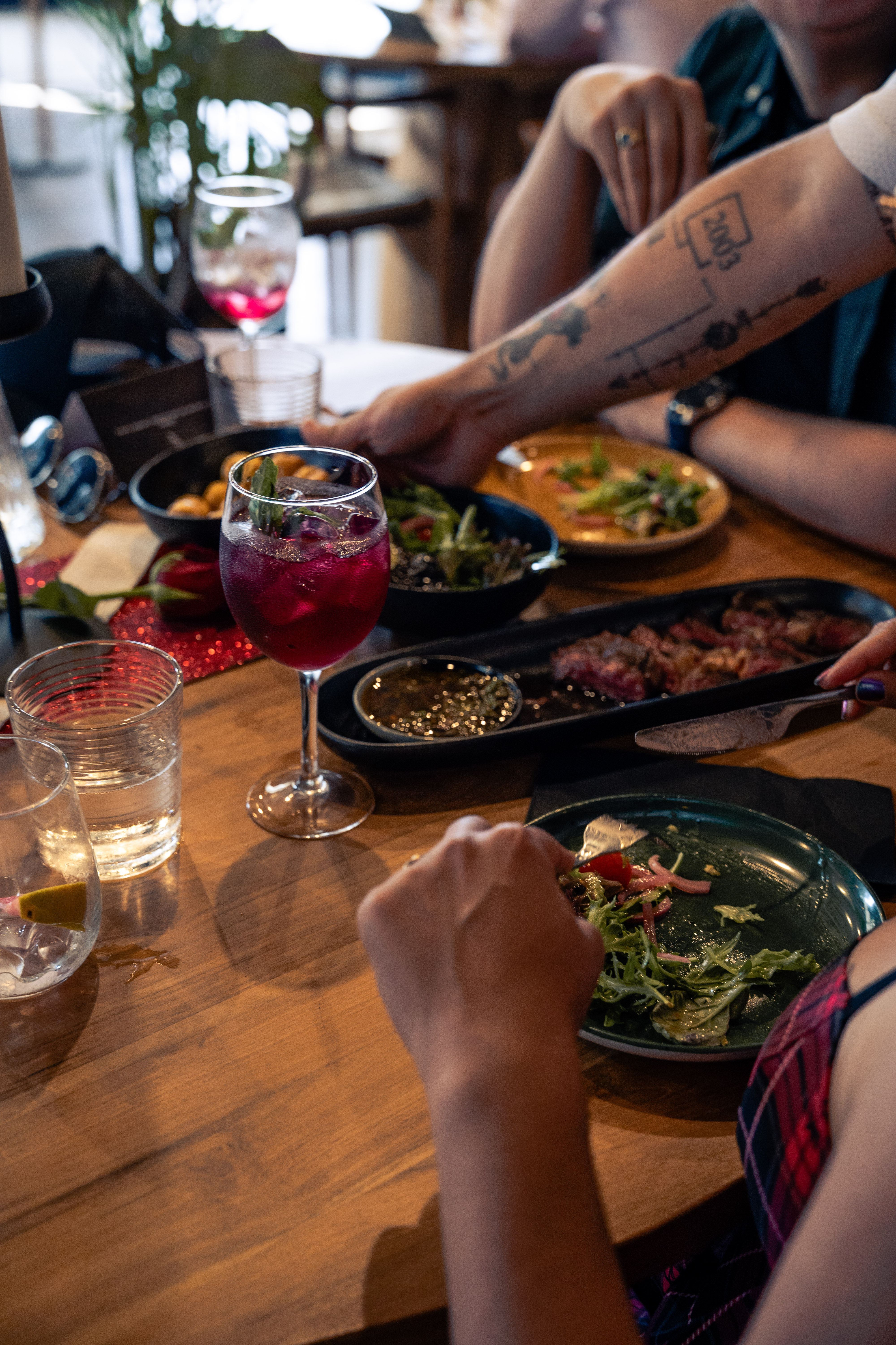 Guests sharing food and drinks at a restaurant table